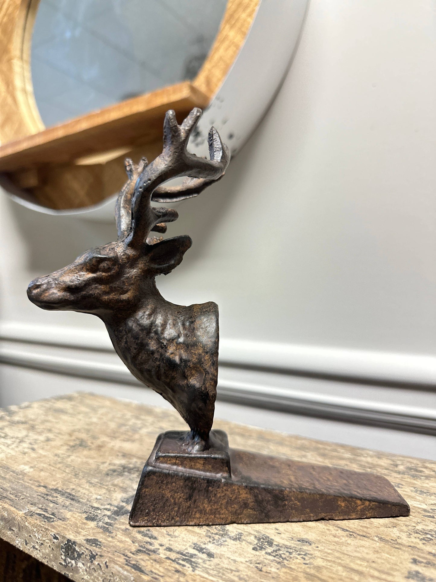 Bronze deer sculpture on a wooden surface with a blurred background