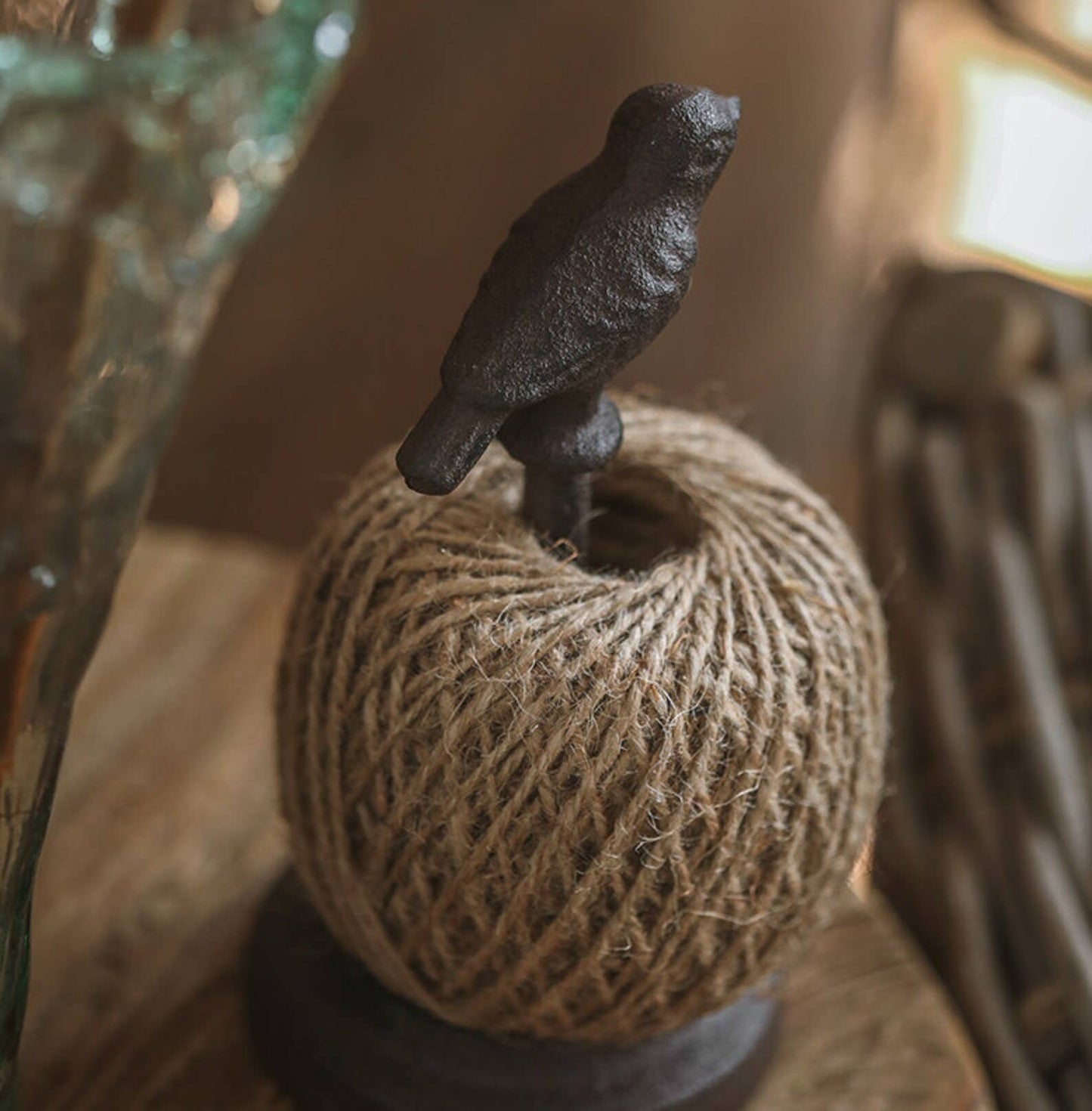 Decorative object with a bird figurine on a textured ball of twine