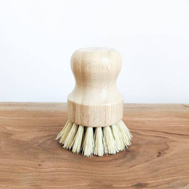 Wooden dish brush with bristle head on a wooden surface