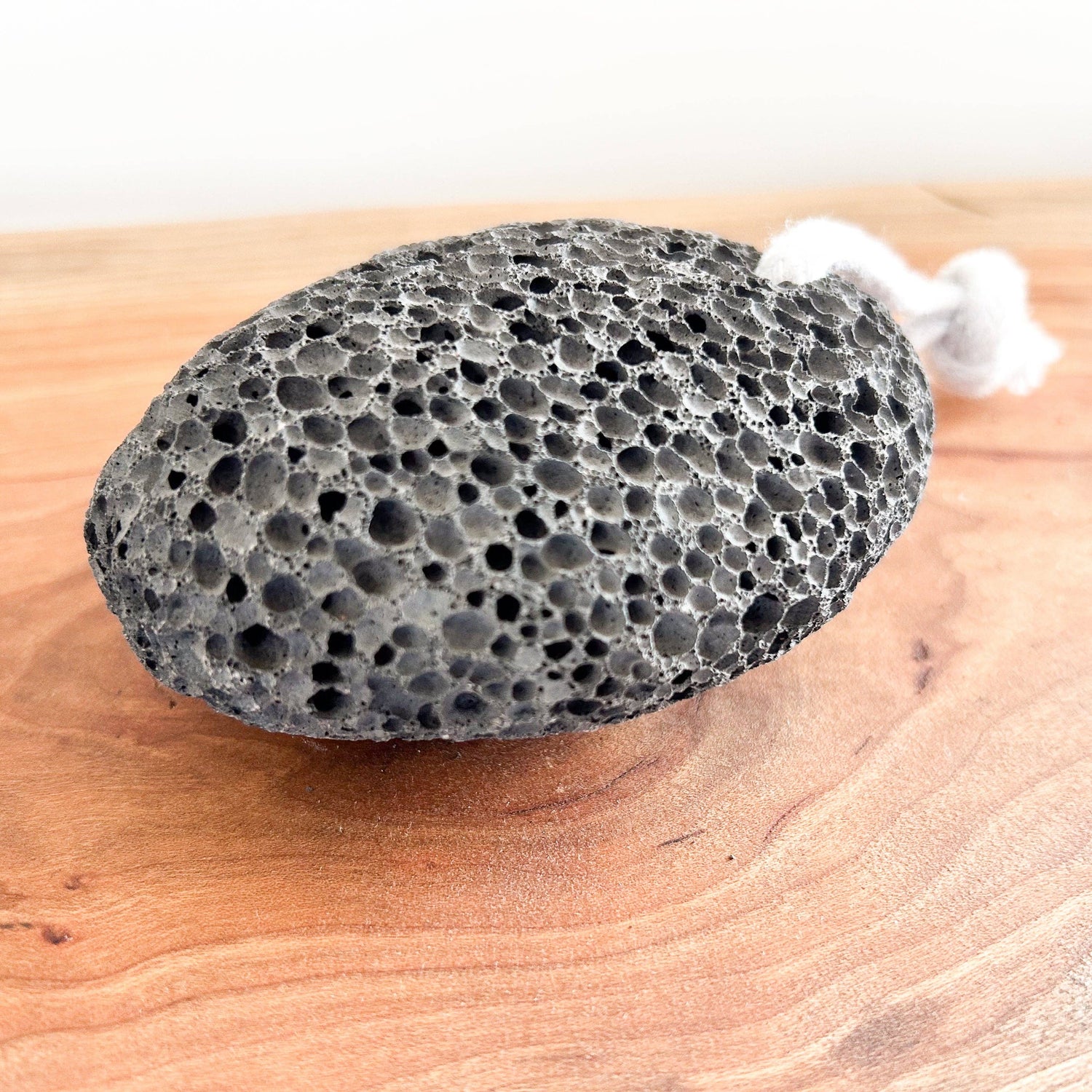 Black volcanic stone with foam on a wooden surface