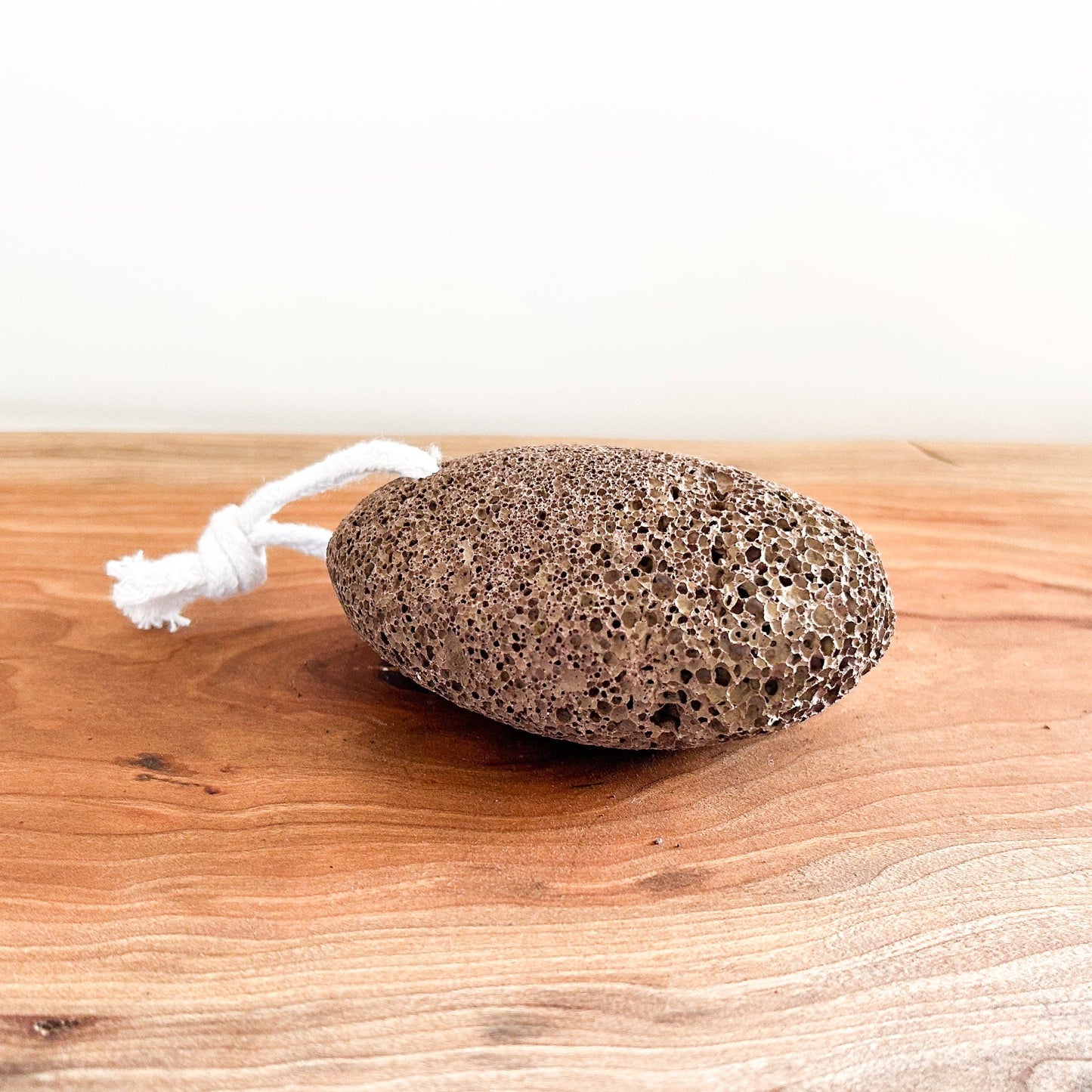 Pumice stone on a wooden surface with a white background