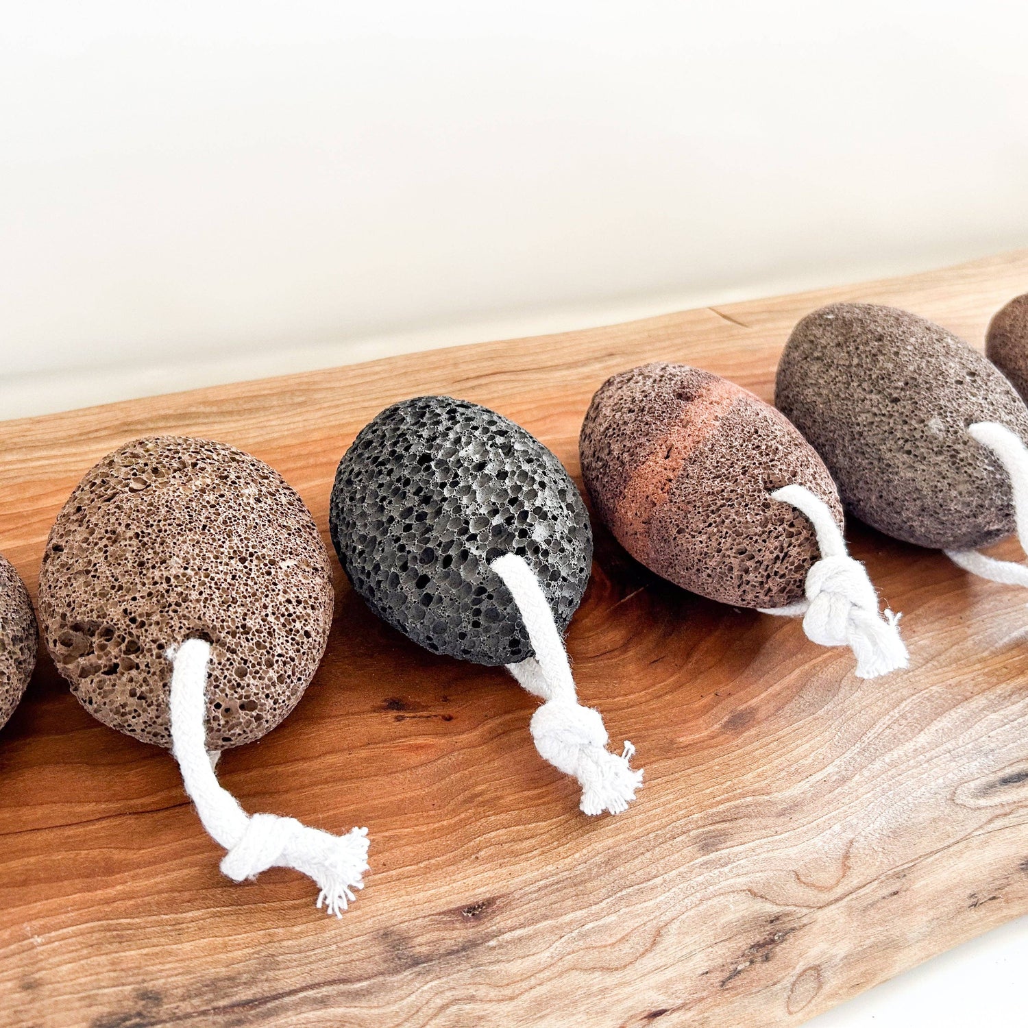 Set of five textured stones with strings on a wooden surface