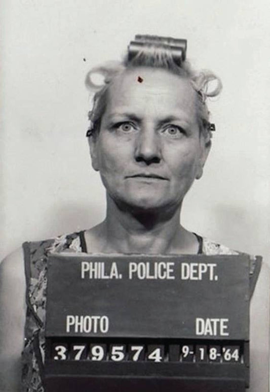 Vintage mugshot of a woman with 'PHILA. POLICE DEPT.' sign