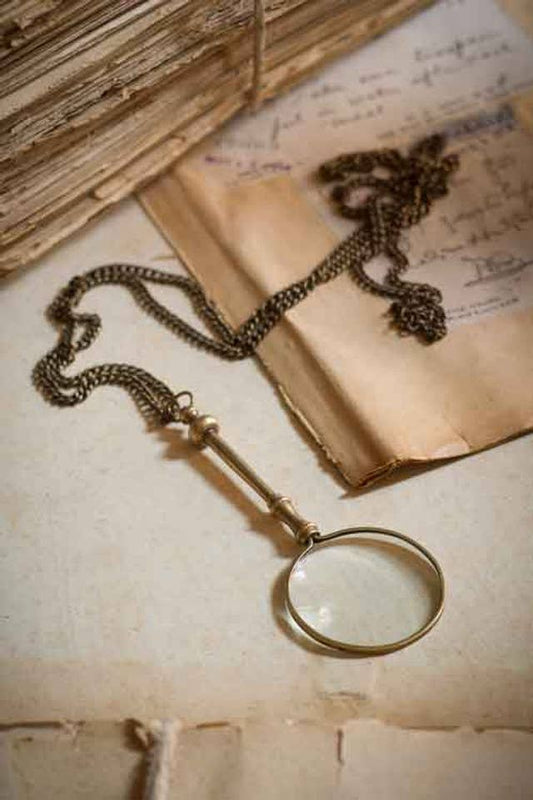 Vintage-style magnifying glass on old papers